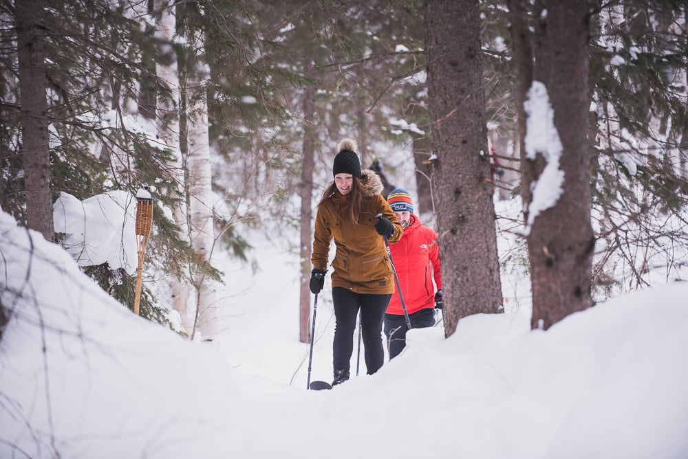 Couple en ski-raquette dans une forêt enneigé au parc national d'Aiguebelle